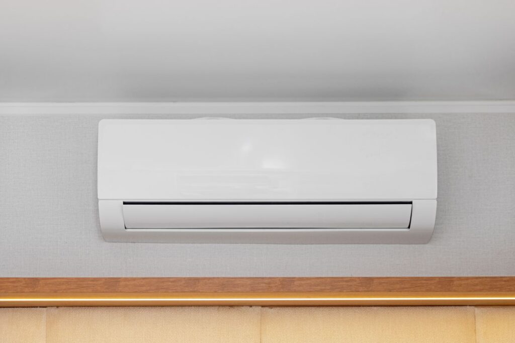 White Air Conditioner Mini Split Unit Mounted at Wall in Room