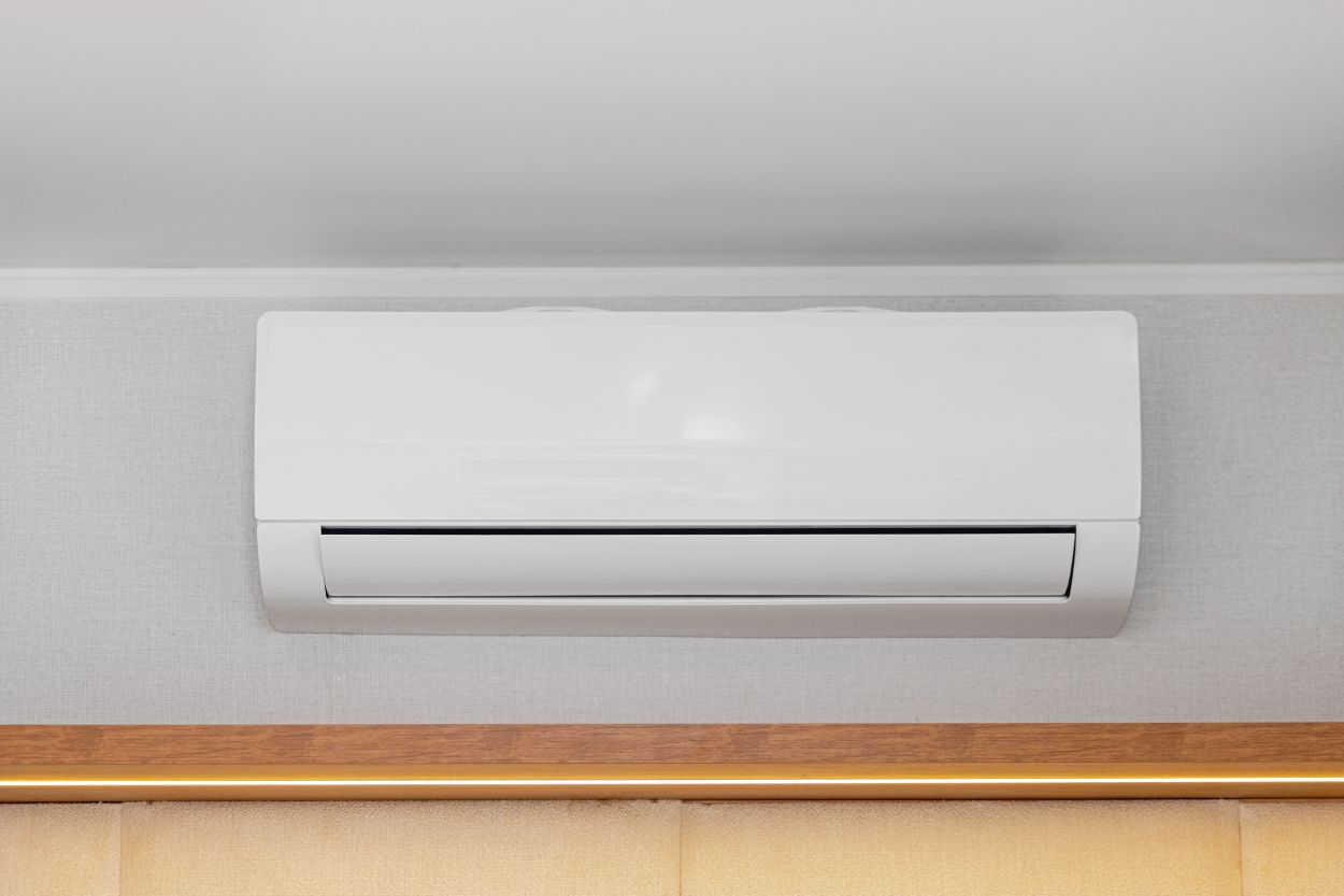 White Air Conditioner Mini Split Unit Mounted at Wall in Room