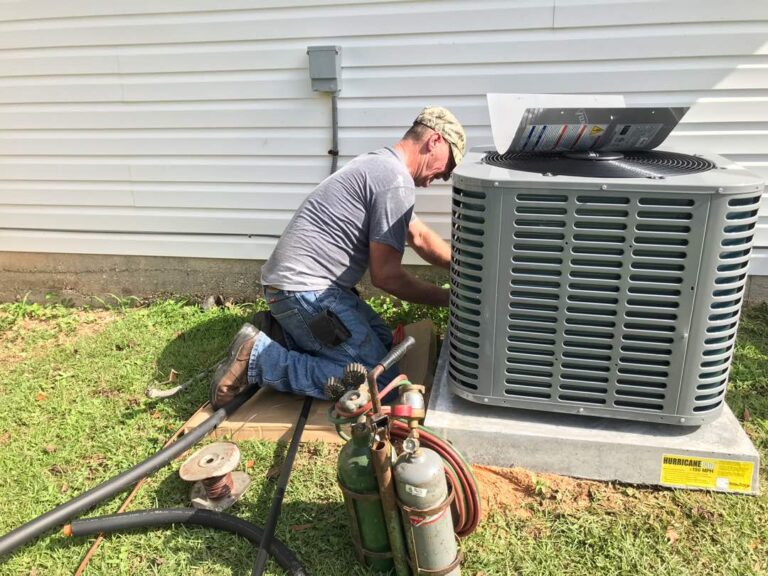 HVAC technician working on an outdoor condenser unit